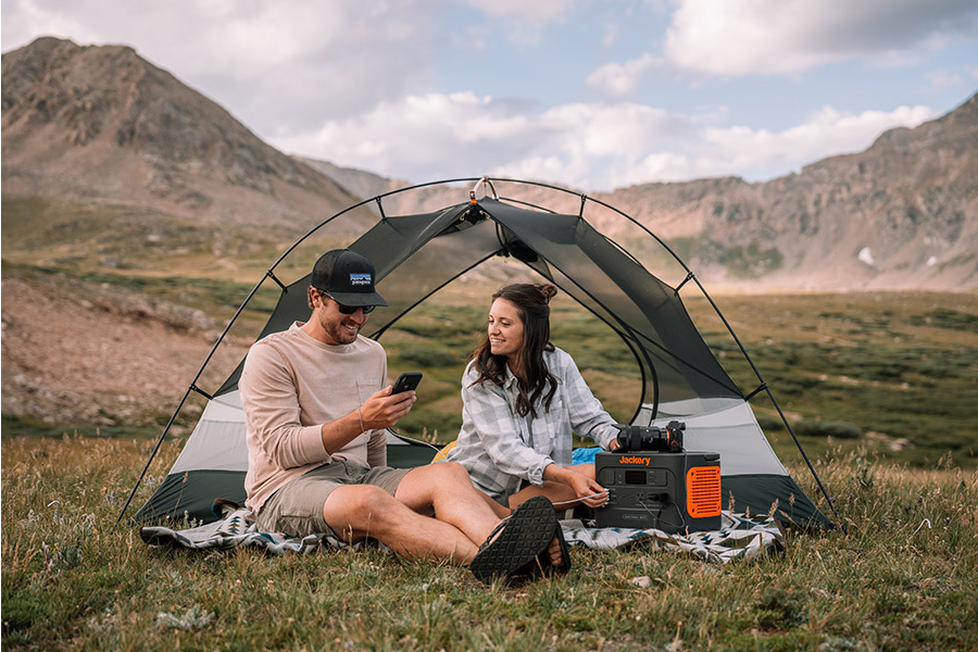 Mladý cestovatelský pár používá Jackery Explorer 1000 Pro na nabíjení mobilu a fotoaparátu